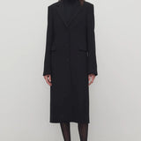 Front view of black cerys coat on model wearing black heels, against a white background.