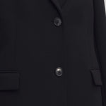 Middle closeup view of black cerys coat on model against a white background.