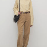 Front view of anise clair pant on model wearing yellow shirt and mules, against a white background.