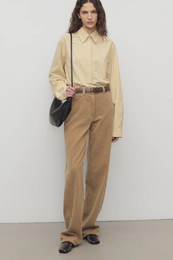 Front view of anise clair pant on model wearing yellow shirt and mules, against a white background.