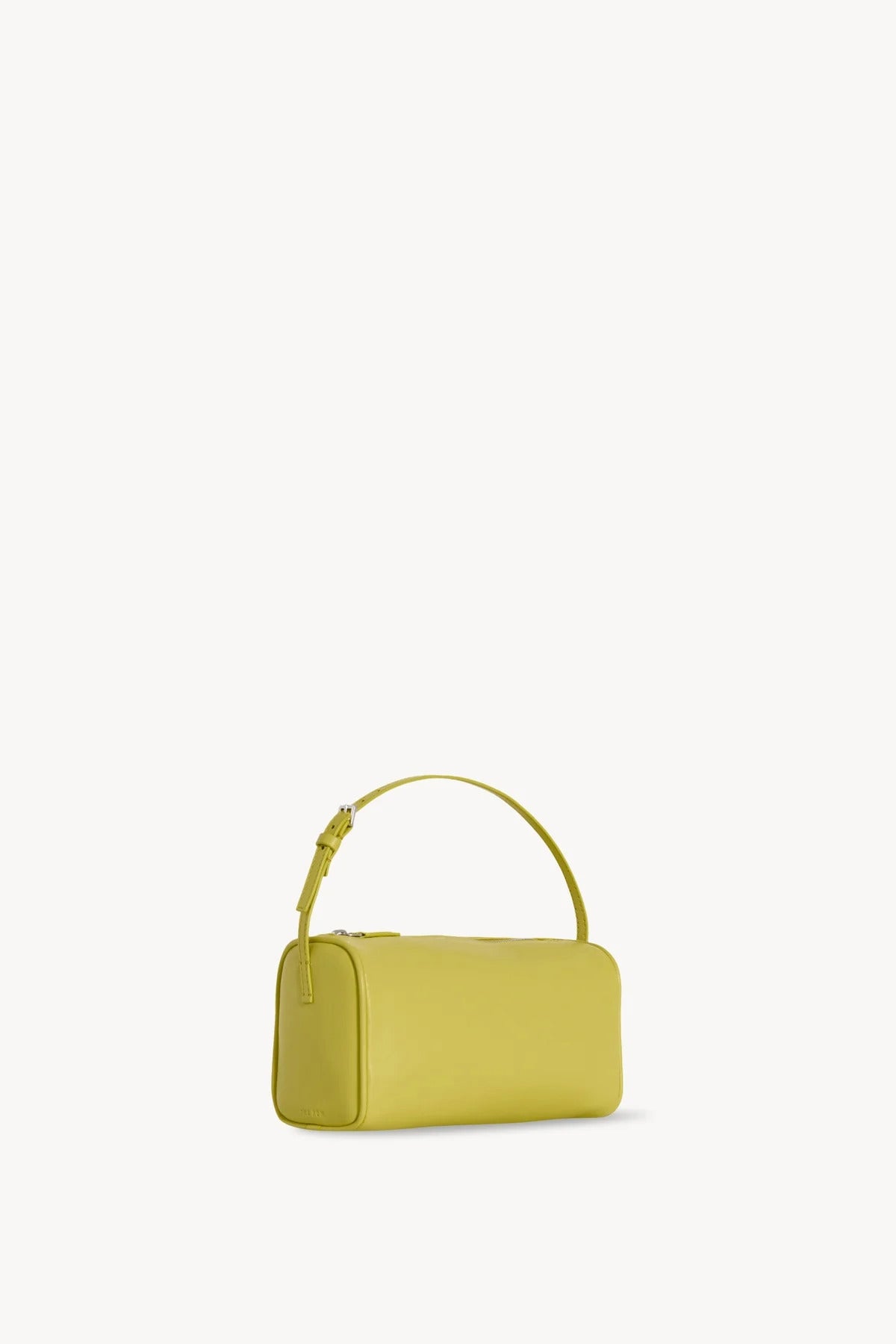 Side slanted view of coppery yellow leather bag on white background, with no model shown.