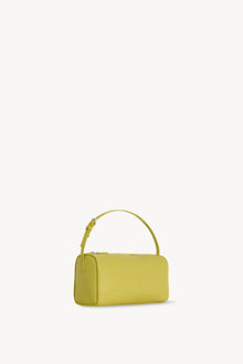 Side slanted view of coppery yellow leather bag on white background, with no model shown.
