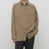 Front view of beige corduroy sislia shirt on model wearing grey pants, against a white background.