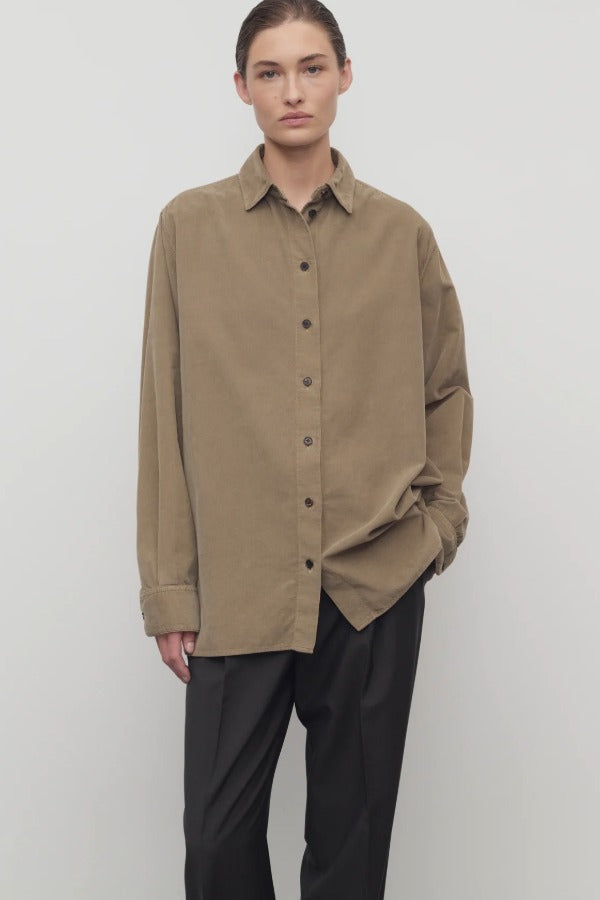 Front view of beige corduroy sislia shirt on model wearing grey pants, against a white background.