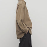 Side view of beige corduroy sisilia shirt on model wearing grey pants, against a white background