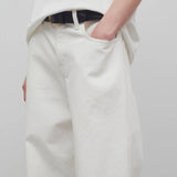 Front closeup view of white eglitta jean on model wearing white t-shirt, against a white background.