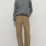 Front view of beige eglitta pant on model wearing grey sweater and boots, against a white background.