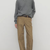 Front view of beige eglitta pant on model wearing grey sweater and boots, against a white background.