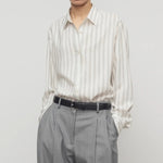 Front view of grey stripe shirt on model wearing grey trousers, against a white background.