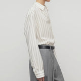 Side view of grey stripe shirt on model wearing grey trousers, against a white background.