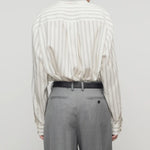 Back view of grey stripe shirt on model wearing grey trousers, against a white background.