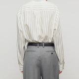 Back view of grey stripe shirt on model wearing grey trousers, against a white background.
