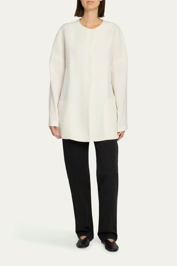 Front view of off white elke jacket on model wearing black pants and ballet flats, against a white background.