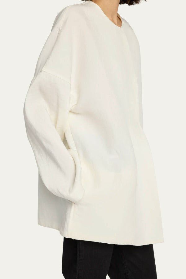 Side view of off white elke jacket on model wearing black pants, against a white background.