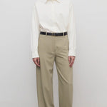 Front view of fossil elowyn pant on model wearing white shirt and black heels, against a white background.