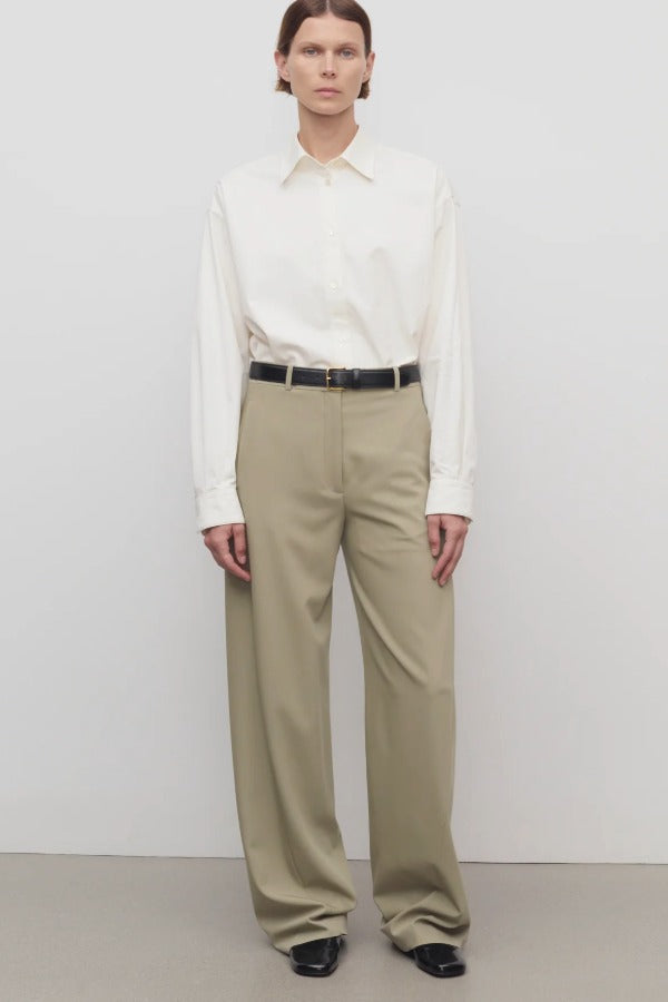 Front view of fossil elowyn pant on model wearing white shirt and black heels, against a white background.
