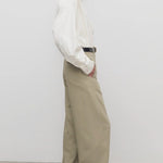 Side view of fossil elowyn pant on model wearing white shirt and heels, against a white background