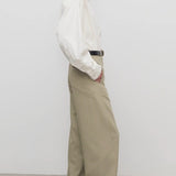 Side view of fossil elowyn pant on model wearing white shirt and heels, against a white background