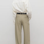 Back view of fossil pant on model wearing white shirt and black heels, against a white background.