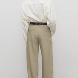 Back view of fossil pant on model wearing white shirt and black heels, against a white background.