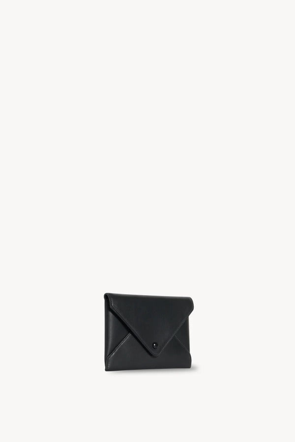 Front slanted view of black envelope clutch on white background, with no model shown.