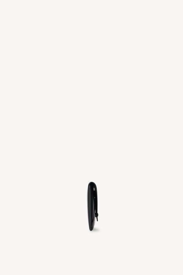 Side view of black envelope clutch on white background, with no model shown.