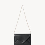 Strap view of black envelope clutch on white background, with no model shown.