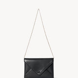 Strap view of black envelope clutch on white background, with no model shown.