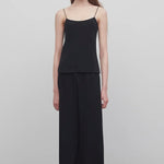 Front view of black gala pant on model wearing black top, against a white background.