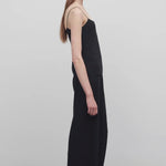 Side view of black gala pant on model wearing black top, against a white background.