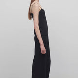Side view of black gala pant on model wearing black top, against a white background.