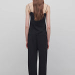 Back view of black gala pant on model wearing black top, against a white background.
