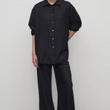 Front view of black gala pant on model wearing black shirt and heels, against a white background.