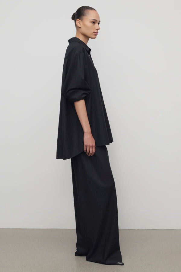 Side view of black gala pant on model wearing black shirt and heels, against a white background.