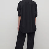 Back view of black gala pant on model wearing black shirt and heels, against a white background.