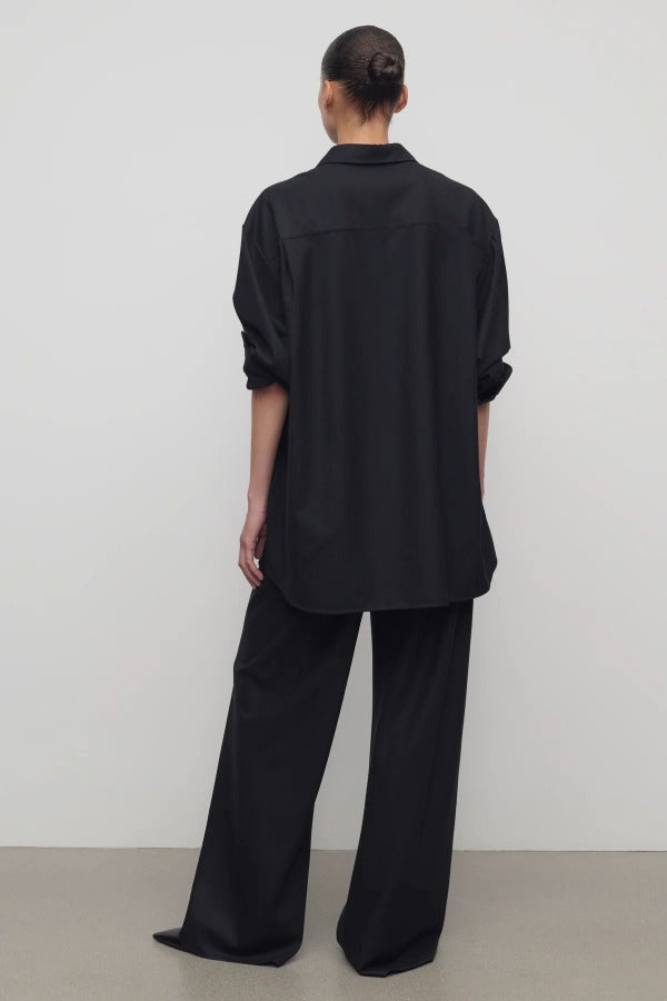 Back view of black gala pant on model wearing black shirt and heels, against a white background.