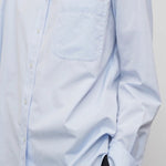Front closeup view of sky blue gavina shirt on model wearing black pants, against a white background.
