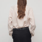 Back view of ivory/cinnamon gavina shirt on model wearing black pants, against a white background.