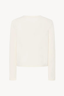 A long-sleeved white cotton button-down sweater is displayed from the back against a plain white background, without a model.