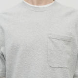Front closeup view of grey melange paddy top on model wearing long sleeve white shirt underneath with black trousers, against a white background.
