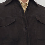 Front closeup view of dark brown gwena jacket on model wearing yellow shirt, against a white background.