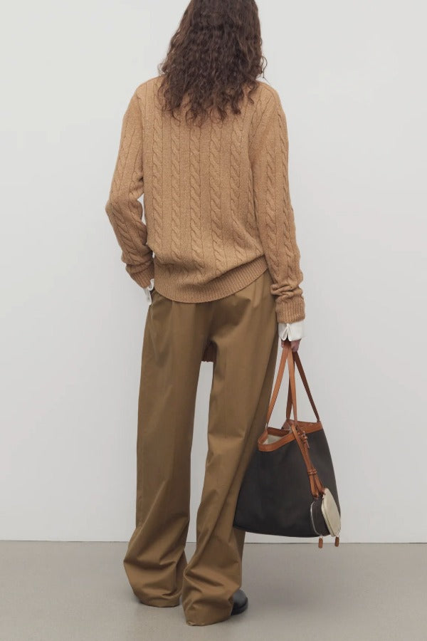 Back view of dsark sand igor pant on model wearing camel sweater and boots, against a white background.