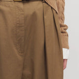 Front closeup view of dark sand igor pant on model wearing camel sweater, against a white background.