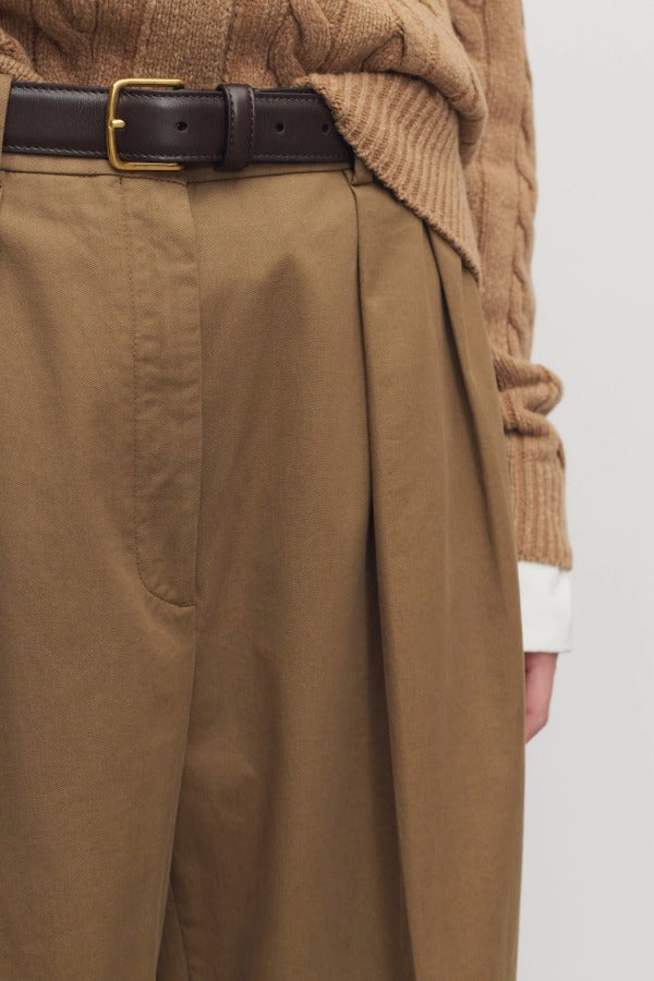 Front closeup view of dark sand igor pant on model wearing camel sweater, against a white background.
