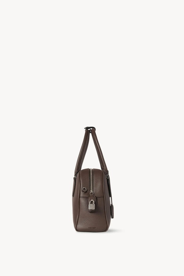 Side view of deep brown india 10 bag on white background, with no model shown.