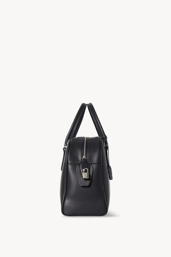 Side view of black india 12 bag on white background with no model shown.