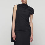 Front view of black isadra top on model wearing black skirt, against a white background.