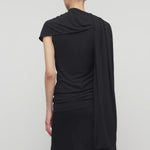 Back view of black isadra top on model wearing black skirt, against a white background.