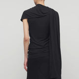 Back view of black isadra top on model wearing black skirt, against a white background.