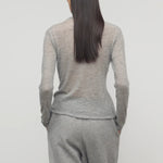 Back view of grey melange iverness top on model wearing grey sweatpants, against a white background.